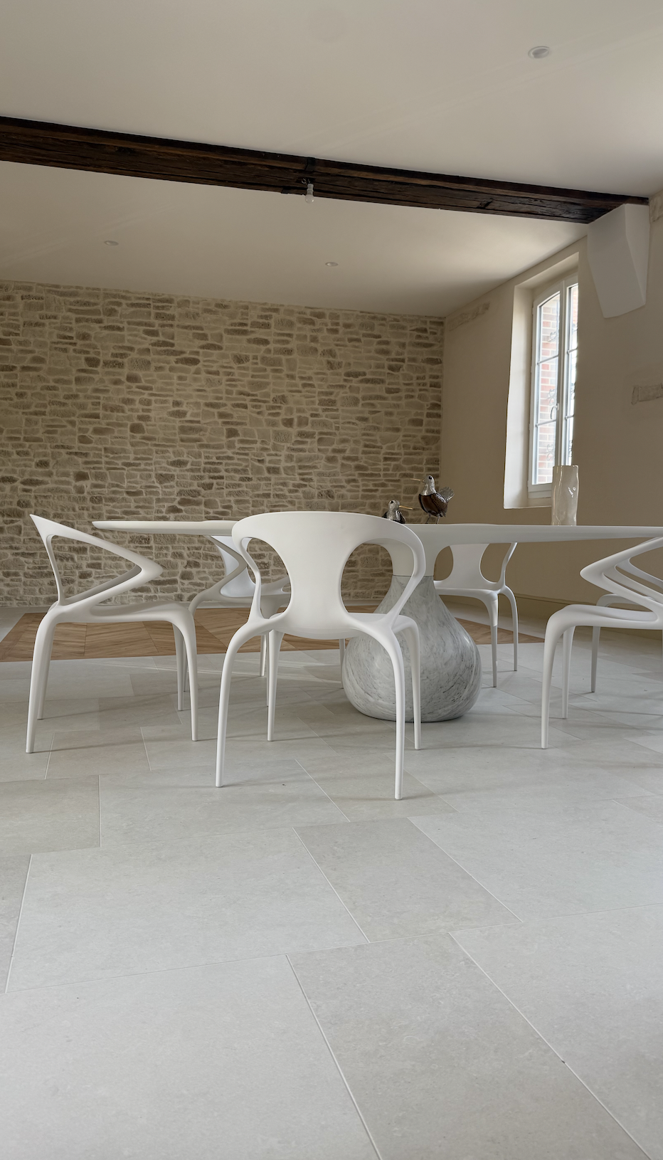 Aménagement d’une salle à manger dans une maison à Volgré avec mobilier Roche Bobois et mur en pierre – projet JBB Architecture par Jean-Baptiste Brulé