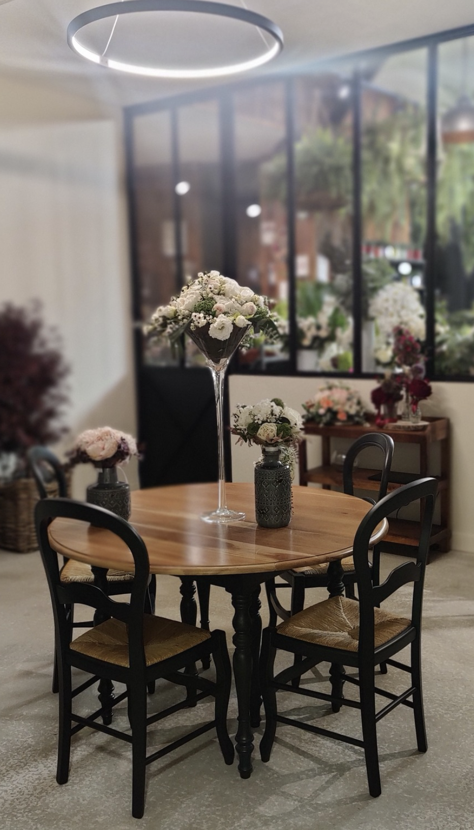 Création intérieure d’un fleuriste à Auxerre avec table décorée de fleurs et verrière moderne – projet JBB Architecture par Jean-Baptiste Brulé