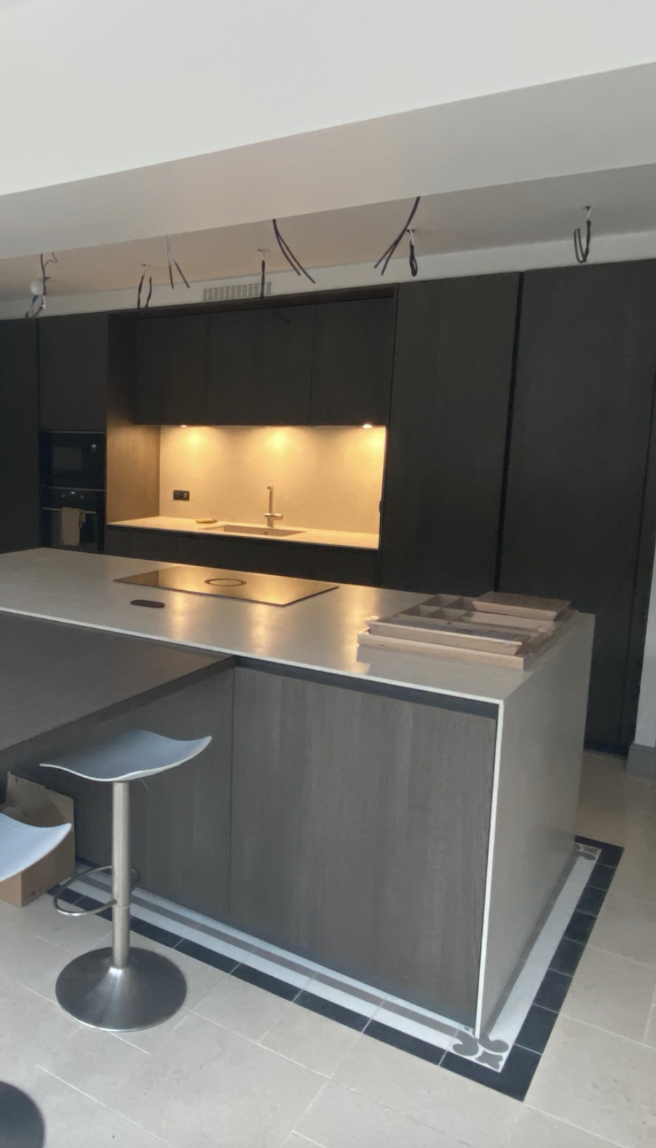 Aménagement d’une cuisine moderne avec îlot central et façade en bois sombre dans une maison rénovée – projet JBB Architecture par Jean-Baptiste Brulé