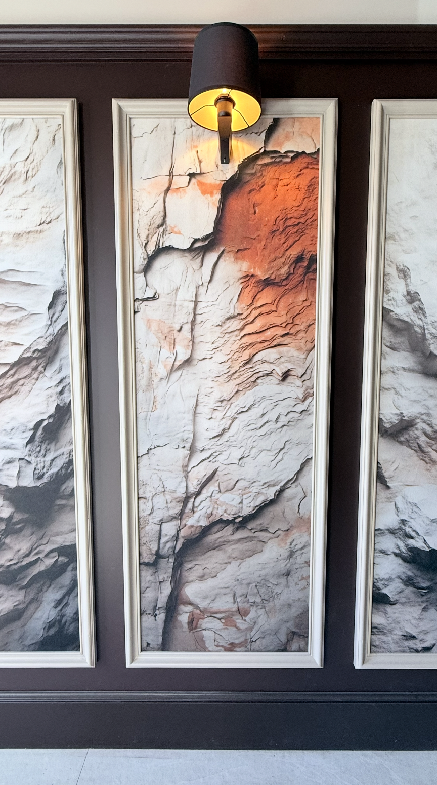 Tableau acoustique à texture minérale conçu par JBB architecte d’intérieur pour le restaurant Le Jean Maurice à Chablis, intégré sur mur sombre avec éclairage directionnel.